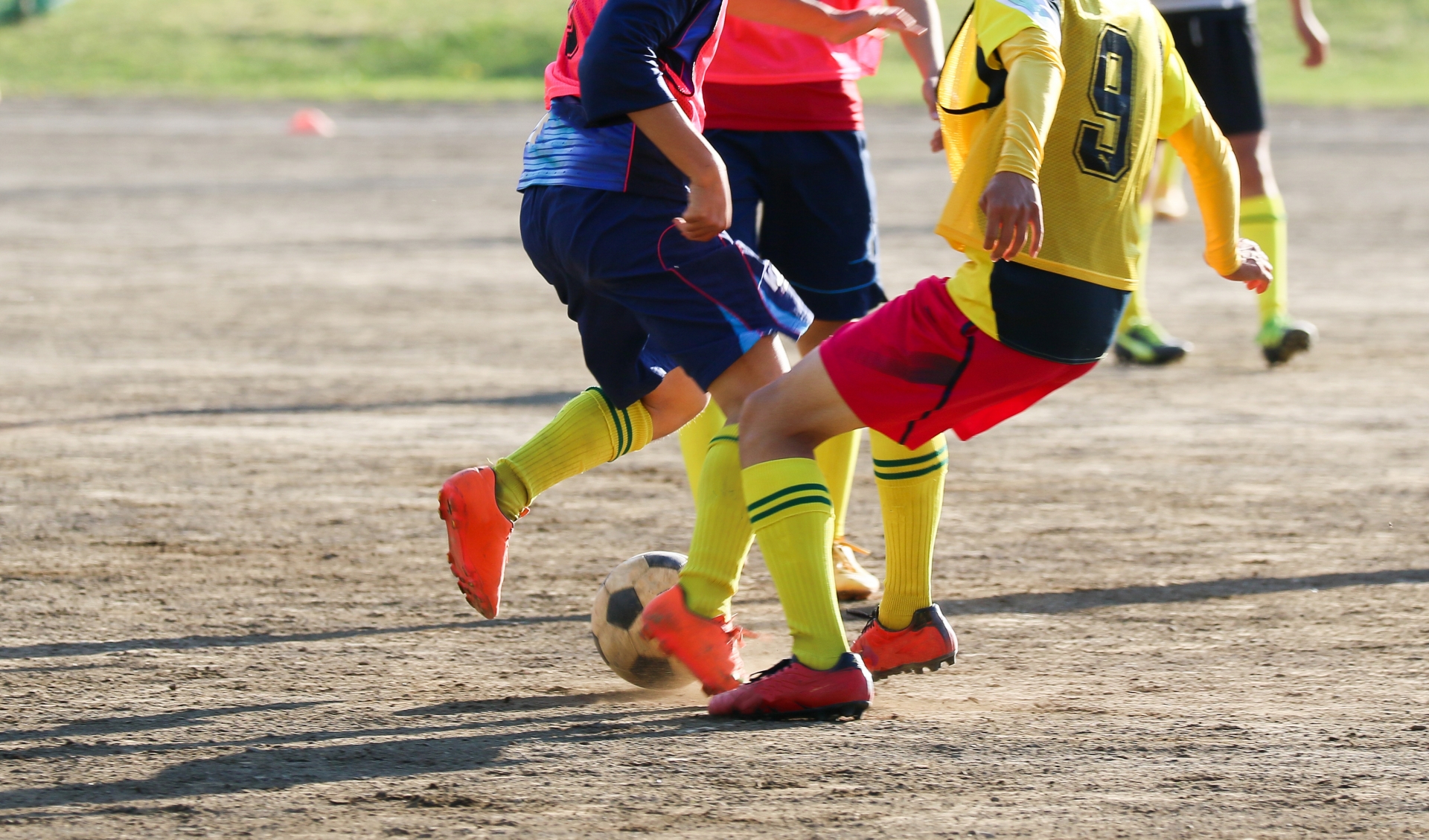 サッカーで相手のボールを奪いに来た少年