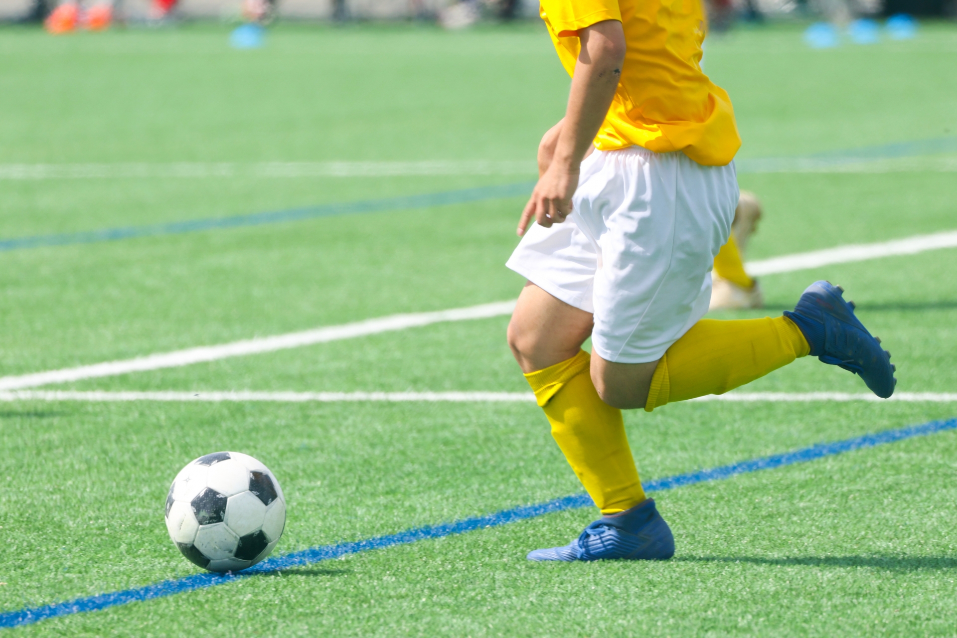 サッカーボールをドリブルする選手